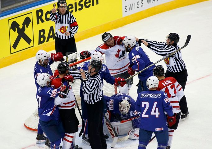 Referees intervene during a scuffle between players of France and Canada in the third period of their men's ice hockey World Championship Group A game at Chizhovka Arena