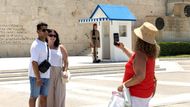 Přes spalující vedro využívají lidé příležitost pořídit si fotku s členem řecké prezidentské gardy před budovou parlamentu v Athénách.
