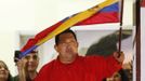 Venezuelan President Hugo Chavez waves the national flag while celebrating from a balcony at the Miraflores Palace in Caracas October 7, 2012. Venezuela's socialist President Chavez won re-election in Sunday's vote with 54 percent of the ballot to beat opposition challenger Henrique Capriles. REUTERS/Jorge Silva (VENEZUELA - Tags: POLITICS ELECTIONS) Published: Říj. 8, 2012, 5:03 dop.