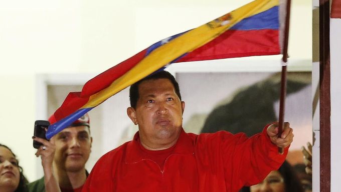 Venezuelan President Hugo Chavez waves the national flag while celebrating from a balcony at the Miraflores Palace in Caracas October 7, 2012. Venezuela's socialist President Chavez won re-election in Sunday's vote with 54 percent of the ballot to beat opposition challenger Henrique Capriles. REUTERS/Jorge Silva (VENEZUELA - Tags: POLITICS ELECTIONS) Published: Říj. 8, 2012, 5:03 dop.