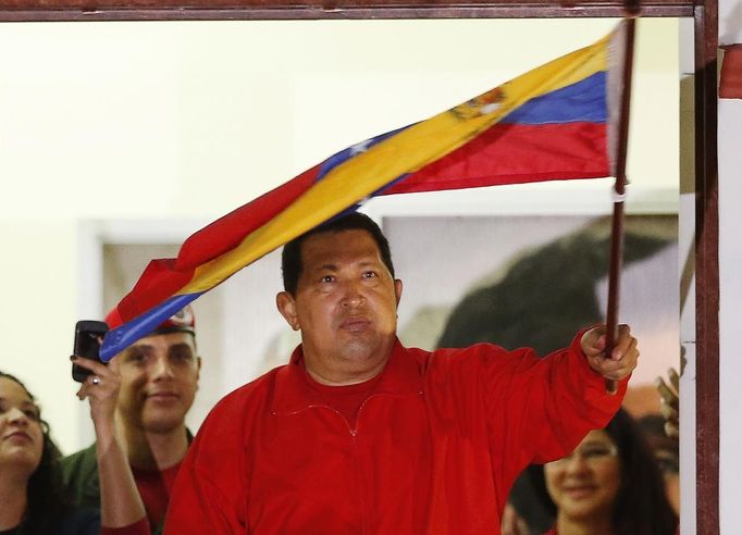 Venezuelan President Hugo Chavez waves the national flag while celebrating from a balcony at the Miraflores Palace in Caracas October 7, 2012. Venezuela's socialist President Chavez won re-election in Sunday's vote with 54 percent of the ballot to beat opposition challenger Henrique Capriles. REUTERS/Jorge Silva (VENEZUELA - Tags: POLITICS ELECTIONS) Published: Říj. 8, 2012, 5:03 dop.