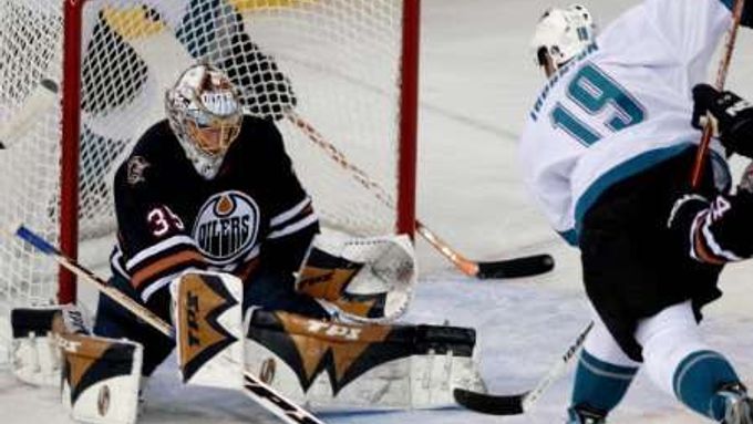 Brankář Edmontonu Oilers Dwayne Roloson zastavil pokus Joea Thorntona z týmu San Jose Sharks v zámořské NHL.