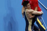 Čínský vzpěrač Siao-ťün Lu zvedá do výše svého trenéra Wang Pao-fu poté, co zvítězil v kategorii do 77 kg.