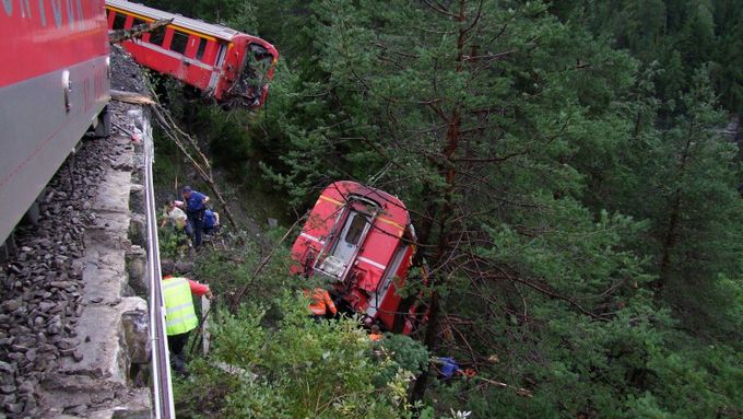 Policie a záchranáři pomáhají pasažérům vykolejeného švýcarského vlaku.