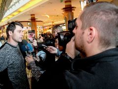 Jan Železný odpovídá po slavnostním předání vydraženého sportovního náčiní v obležení novinářů.