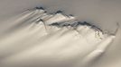 Aerial of a windswept nunatak on the Harding Ice Field in Kenai Fjords National Park, Southcentral Alaska, Winter