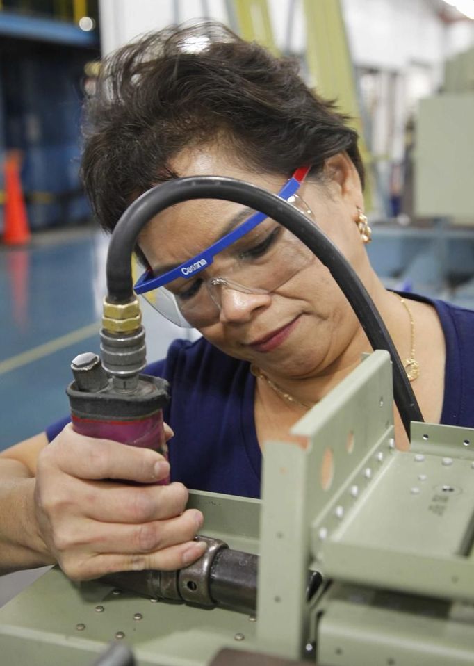 Cessna employee Julie Cao works on the line during a tour of the Cessna business jet assembly line at their manufacturing plant in Wichita, Kansas August 14, 2012. One of Cessna Aircraft Company CEO and president Scott Ernes' first moves after joining in May 2011 was to carve Cessna up into five units, each of which run by an executive who was responsible for whether the unit reported a profit or loss. Picture taken August 14, 2012. REUTERS/Jeff Tuttle (UNITED STATES - Tags: TRANSPORT BUSINESS) Published: Srp. 22, 2012, 11:40 dop.