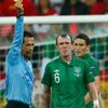 Glenn Whelan dostává žlutou kartu v utkání Španělska s Irskem ve skupině C na Euru 2012
