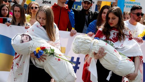 Ženy při demonstraci na podporu Ukrajiny v Budapešti nesou figuríny dětí, které symbolizují oběti konfliktu.