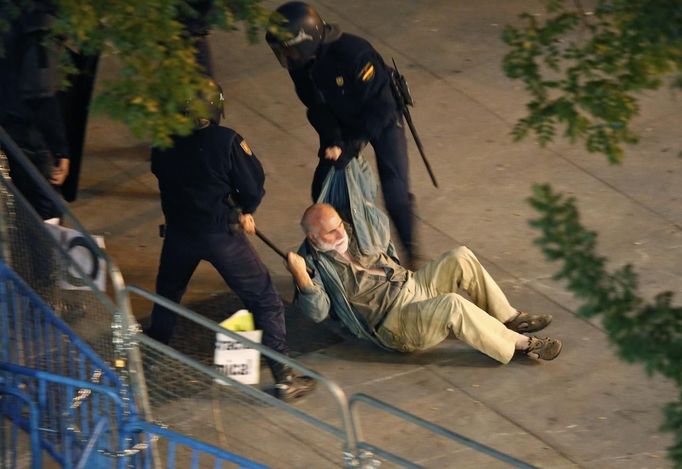 A protester is dragged away by police during a demonstration outside the Spanish parliament in Madrid, September 25, 2012. Police prepared on Tuesday for anti-austerity demonstrations in Spain's capital ahead of the government's tough 2013 budget that will cut into social services as the country teeters on the brink of a bailout. REUTERS/Sergio Perez (SPAIN - Tags: CIVIL UNREST POLITICS) Published: Zář. 25, 2012, 8:06 odp.