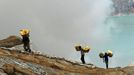 This photo taken on December 25, 2010 shows Indonesian miners carrying baskets of sulphur from the bottom of the crater of Indonesia's active Kajah Iwen volcano, in the e