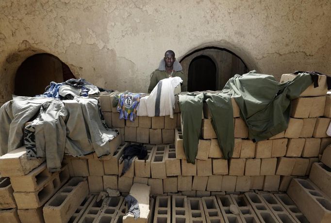 A Malian soldier dries military uniforms in the recently liberated town of Diabaly January 24, 2013. REUTERS/Eric Gaillard (MALI - Tags: CIVIL UNREST CONFLICT MILITARY POLITICS) Published: Led. 24, 2013, 6:48 odp.