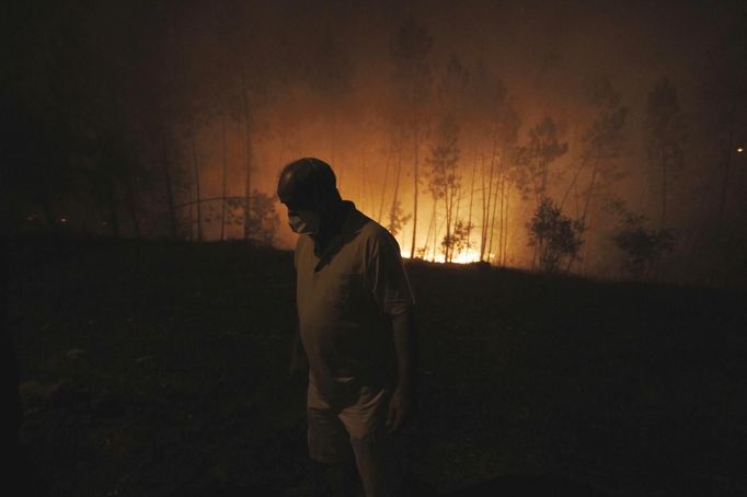 A man wearing a face mask looks at the fire near his house in Ribeira do Farrio, near Ourem September 3, 2012. According to the civil defence, over 1,700 firefighters have been mobilized to tackle more than 10 forest fires currently active in Portugal. A man died and three people were injured so far. REUTERS/Rafael Marchante (PORTUGAL - Tags: DISASTER ENVIRONMENT) Published: Zář. 4, 2012, 12:34 dop.