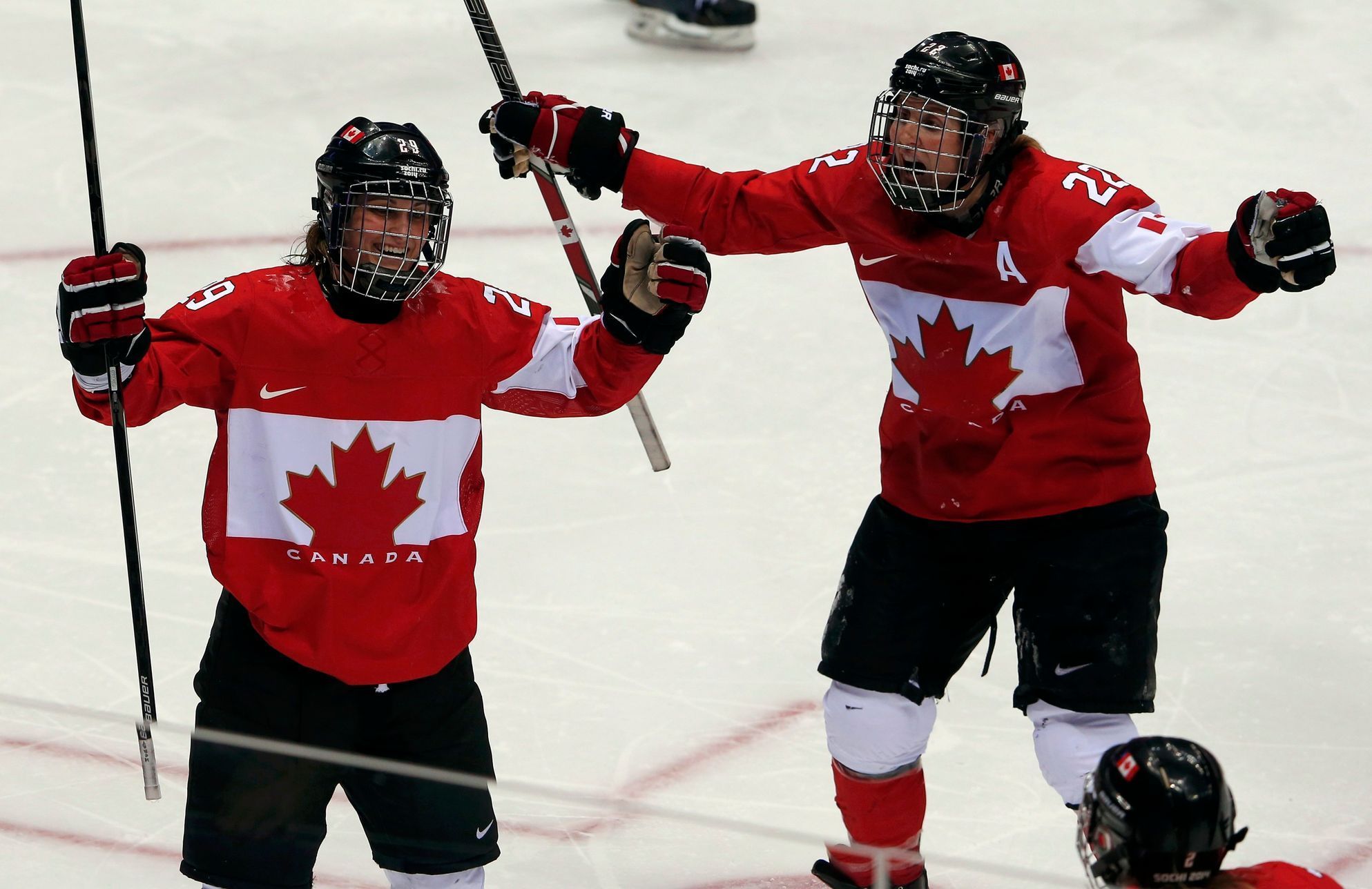 Canada's Poulin celebrates her gold medal-winning overtime goal against Team USA with teammate Wickenheiser at the Sochi 2014 Winter Olympic Games
