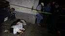 A man (L) mourns next to the body of a slain relative at a crime scene in the city of San Pedro Sula March 22, 2013. Unknown assailants killed three men and one woman on Friday at the crime scene in a working class neighbourhood, local media reported. San Pedro Sula has been labelled the most violent city on the planet, according to a U.N. Development Program report last week. Picture taken March 22, 2013. REUTERS/Jorge Cabrera (HONDURAS - Tags: CIVIL UNREST CRIME LAW) Published: Bře. 23, 2013, 9:02 odp.