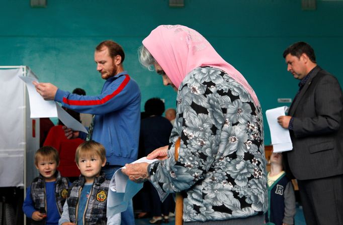 Žena si prohlíží hlasovací lístek ve volební místnosti v jihoruském Stavropolu.