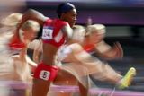 Záběr na americkou sprinterku Kellie Wellsovou při překážkovém běhu na 100 metrů.