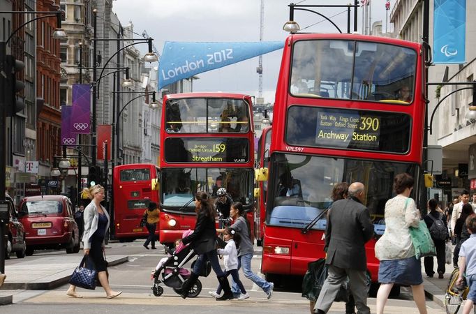 Double decker buses drive past posters of Olympic Rings and flags advertising the London 2012 Olympics at Oxford Street in London July 13, 2012. The London 2012 Olympics run from July 27 to August 12. REUTERS/Fabrizio Bensch (BRITAIN - Tags: SPORT OLYMPICS TRANSPORT) Published: Čec. 13, 2012, 2:40 odp.