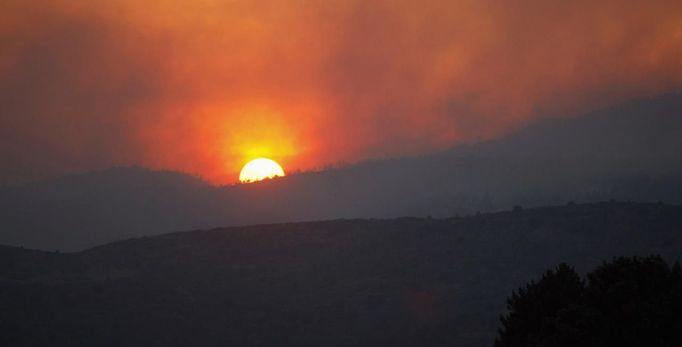 The setting sun is obscured by smoke from the Waldo Canyon Fire, west of Colorado Springs June 24, 2012. The fast-growing wildfire that blew up overnight in Colorado has forced 11,000 people from their homes and was threatening popular summer camping grounds beneath Pikes Peak, billed as the most visited mountain in North America. REUTERS/Rick Wilking (UNITED STATES - Tags: DISASTER ENVIRONMENT) Published: Čer. 25, 2012, 2:50 dop.