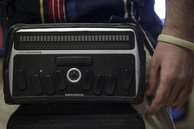 Braillenote, a computer with a refreshable Braille display for the blind or visually impaired users, hangs from the shoulder of a student at the World Services for the Blind (WSB) in Little Rock, Arkansas January 7, 2013. The WSB is a rehabilitation center for the blind or visually impaired which offers life skills and career training programs designed to help those enrolled achieve sustainable independence. Picture taken on January 7, 2013. REUTERS/Gaia Squarci (UNITED STATES - Tags: HEALTH EDUCATION SOCIETY SCIENCE TECHNOLOGY) Published: Dub. 26, 2013, 2:10 odp.