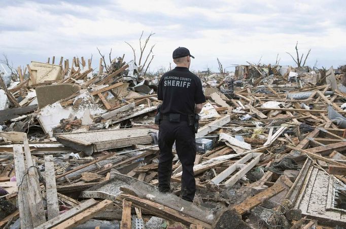 Oklahoma County Sheriff's Deputy Erik Gransberg searches for victims in rubble at a residential area of Moore, Oklahoma May 21, 2013. Rescuers went building to building in search of victims and thousands of survivors were homeless on Tuesday, a day after a massive tornado tore through a suburb of Oklahoma City, wiping out whole blocks of homes and killing at least 24 people. REUTERS/Richard Rowe (UNITED STATES - Tags: DISASTER ENVIRONMENT) Published: Kvě. 21, 2013, 11:39 odp.