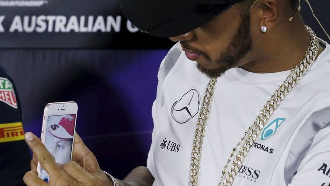 Lewis Hamilton si na tiskové konferenci v Melbourne fotografuje Sebastiana Vettela.