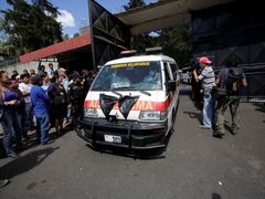 Sanitka odváží těla obětí požáru v guatemalském ústavu.