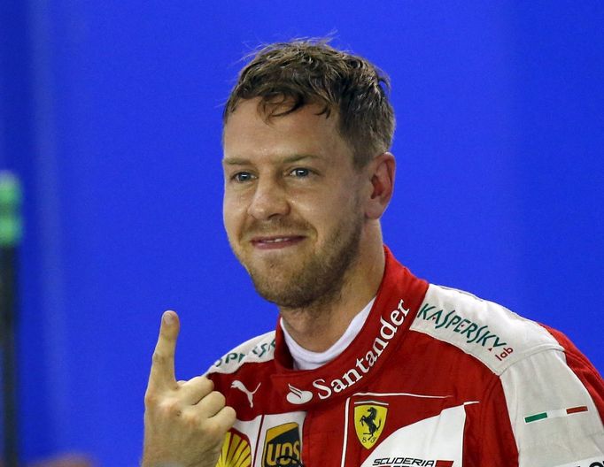 Ferrari Formula One driver Sebastian Vettel of Germany gestures after qualifying for the Singapore F1 Grand Prix at the Marina Bay street circuit September 19, 2015. REUT