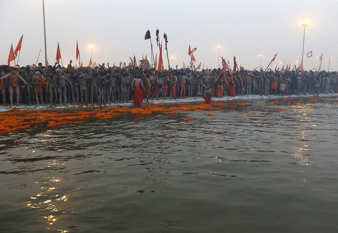 Naga Sadhus or Hindu holymen prepare to take a holy dip during first "Shahi Snan" (grand bath) at the ongoing "Kumbh Mela", or Pitcher Festival, in the northern Indian city of Allahabad January 14, 2013. Upwards of a million elated Hindu holy men and pilgrims took a bracing plunge in India's sacred Ganges river to wash away lifetimes of sins on Monday, in a raucous start to an ever-growing religious gathering that is already the world's largest. REUTERS/Ahmad Masood (INDIA - Tags: RELIGION SOCIETY) TEMPLATE OUT Published: Led. 14, 2013, 8:35 dop.