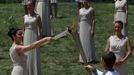 Greek actress Ino Menegaki (L), playing the role of High Priestess, lights the torch held by Spyridon Gianniotis, Greece's world champion of swimming, during a dress rehearsal for the torch lighting ceremony of the London 2012 Olympic Games at the site of ancient Olympia in Greece May 9, 2012. The official lighting ceremony for the London Games will take place on May 10. REUTERS/John Kolesidis (GREECE - Tags: SPORT OLYMPICS) Published: Kvě. 9, 2012, 11:25 dop.