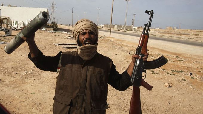 Muž v Tobruku na východě Libye ukazuje zbraně a munici, kterou za sebou zanechaly Kaddáfího oddíly.