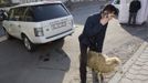 A man speaks on a phone as he holds a sheep for slaughtering after Kurban-Ait, also known as Eid al-Adha in Arabic, prayer in front of Central Mosque in Almaty October 26, 2012. Muslims around the world celebrate Eid al-Adha, marking the end of the haj, by slaughtering sheep, goats, cows and camels to commemorate Prophet Abraham's willingness to sacrifice his son Ismail on God's command. REUTERS/Shamil Zhumatov (KAZAKHSTAN - Tags: RELIGION SOCIETY) Published: Říj. 26, 2012, 7:29 dop.