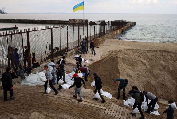Dobrovolníci v Oděse stavějí zátarasy na pobřeží Černého moře.