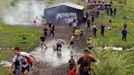 Zombies chase runners on the "Run for Your Lives" 5K obstacle course race in Amesbury, Massachusetts May 5, 2012. Runners face man-made and natural obstacles on the course, while being chased by zombies, who try to take "health" flags off the runners belts. REUTERS/Brian Snyder (UNITED STATES - Tags: SPORT SOCIETY) Published: Kvě. 5, 2012, 10:29 odp.