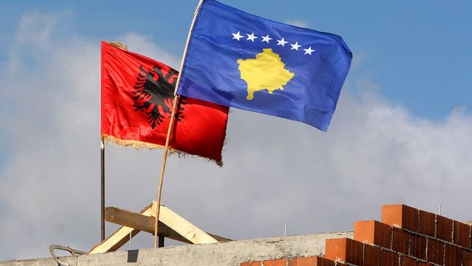 Nová modrá vlajka Kosova vlaje vedle červené albánské vlajky na rozestavěném domě na okraji Podujeva.