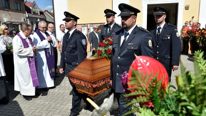 Pohřeb Františka Čuby, hasiči vynášejí rakev z kostela.