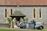 Nevěsta se svým otcem přijíždí jaguarem z roku 1951 před kostel v Englefieldu.