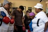 Účastnice tréninkového programu „Boxující babičky“ při společné modlitbě se svým trenérem. Tělocvična „A Team Gym“ jej spustila před čtyřmi lety a od té doby je o něj velký zájem.