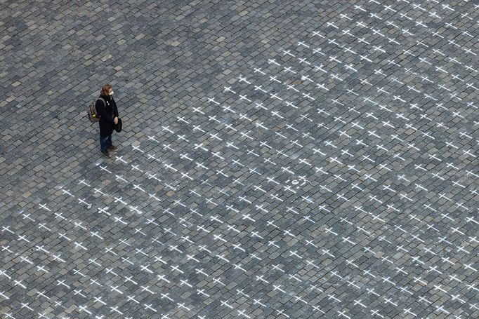 Lidé na Staroměstském náměstí v Praze spontánně uctívají oběti pandemie u křížů, které zde křídou nakreslila iniciativa Milion chvilek pro demokracii. 24 - 25. 3. 2021