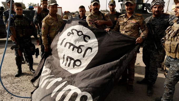 Iráčtí vojáci pózují s vlajkou organizace Islámský stát.