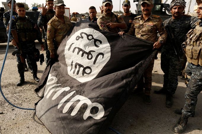 Iráčtí vojáci pózují s vlajkou organizace Islámský stát.