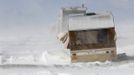 An abandoned caravan is buffeted by winds and drifting snow on the South Downs near Brighton in southern England March 12, 2013. Drivers were left stranded on Tuesday following a second day of heavy snowfall in southern England. REUTERS/Luke MacGregor (BRITAIN - Tags: ENVIRONMENT SOCIETY) Published: Bře. 12, 2013, 5:01 odp.