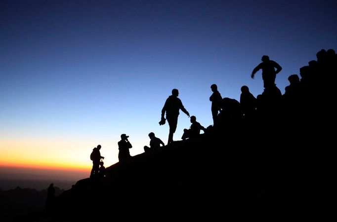 Turisté šplhají na vrcholek Mojžíšovy hory na Sinajském poloostrově, aby sledovali východ slunce 23. července 2010. Podle Bible je toto místo, kde obdržel Mojžíš desatero přikázání od Boha. REUTERS/Goran Tomasevic