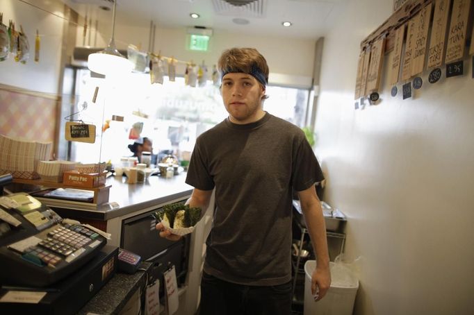 Steffen Andrews, a 24 year-old waiter, serves a customer at Sunny Blue restaurant in Santa Monica, California April 24, 2012. Andrews studied for four and a half years at Cabrillo College where he received a degree in communications. He came to Los Angeles to work in the film industry but is now unsure what career he wants to pursue.