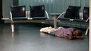 A passenger sleeps at the terminal of German air carrier Lufthansa at the Fraport airport in Frankfurt, September 7, 2012. German air carrier Lufthansa passengers face widespread flight disruption after cabin crew representatives said they continue a series of strikes over pay and cost-cutting measures at Germany's largest airline. The UFO union, which represents around two-thirds of Lufthansa's 19,000 cabin crew called on its members to strike for 24 hours on all German airports on Friday. REUTERS/Kai Pfaffenbach (GERMANY - Tags: TRANSPORT BUSINESS CIVIL UNREST EMPLOYMENT) Published: Zář. 7, 2012, 6:15 dop.