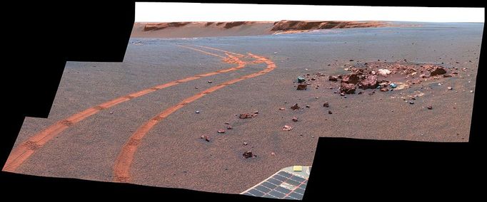 D-Star Panorama by Opportunity (False Color) NASA's twin Mars Exploration Rovers have been getting smarter as they get older. This view from Opportunity shows the tracks left by a drive executed with more onboard autonomy than has been used on any other drive by a Mars rover. Opportunity made the curving, 15.8-meter (52-foot) drive during its 1,160th Martian day, or sol (April 29, 2007). It was testing a navigational capability called "Field D-star," which enables the rover to plan optimal long-range drives around any obstacles in order to travel the most direct safe route to the drive's designated destination. Opportunity and its twin, Spirit, did not have this capability until the third year after their January 2004 landings on Mars. Earlier, they could recognize hazards when they approached them closely, then back away and try another angle, but could not always find a safe route away from hazards. Field D-Star and several other upgrades were part of new onboard software uploaded from Earth in 2006. The Sol 1,160 drive by Opportunity was a Martian field test of Field D-Star and also used several other features of autonomy, including visual odometry to track the rover's actual position after each segment of the drive, avoidance of designated keep-out zones, and combining information from two sets of stereo images to consider a wide swath of terrain in analyzing the route. Two days later, on Sol 1,162, (May 1, 2007), Opportunity was still at the location it reached during that drive, and the rover's panoramic camera (Pancam) took the exposures combined into this image. Victoria Crater is in the background, at the top of the image. The Sol 1,160 drive began at the place near the center of the image where tracks overlap each other. Tracks farther away were left by earlier drives nearer to the northern rim of the crater. For scale, the distance between the parallel tracks left by the rover's wheels is about 1 meter (39 inches) from the middle of one track to the middle of the other. The rocks in the center foreground are roughly 7 to 10 centimeters (3 to 4 inches) tall. The rover could actually drive over them easily, but for this test, Settings in the onboard hazard-detection software were adjusted to make these smaller rocks be considered dangerous to the rover. The patch of larger rocks to the right was set as a keep-out zone. The location from which this image was taken is where the rover stopped driving to communicate with Earth. A straight line from the starting point to the destination would be 11 meters (36 feet). Opportunity plotted and followed a smoothly curved, efficient path around the rocks, always keeping the rover in safe areas. This view combines separate images taken through the Pancam filters centered on wavelengths of 753 nanometers, 535 nanometers and 432 nanometers. It is presented in a false-color stretch to bring out subtle color differences in the scene. Image credit: NASA/JPL-Caltech/Cornell University