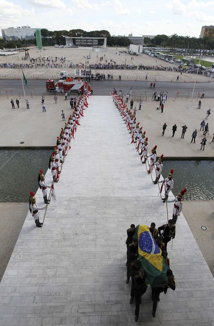 Guards carry the coffin of Oscar Niemeyer at Planalto Palace in Brasilia December 6, 2012. Niemeyer, a towering patriarch of modern architecture who shaped the look of modern Brazil and whose inventive, curved designs left their mark on cities worldwide, died late on Wednesday. He was 104. Niemeyer had been battling kidney and stomach ailments in a Rio de Janeiro hospital since early November. His death was the result of a lung infection developed this week, the hospital said, little more than a week before he would have turned 105. REUTERS/Paulo Whitaker (BRAZIL - Tags: OBITUARY SOCIETY) Published: Pro. 6, 2012, 7 odp.