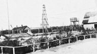 Pohled na tábor v Sobiboru pořízený na jaře 1943 z obytných prostor německého personálu. Vlevo od vysoké protipožární věže (uprostřed) byla táborová pekárna. Přes střechu je vidět rameno bagru, který sloužil k transportu mrtvých těl do masových hrobů. Ze strážní věže nalevo sledovali dozorci vězně na cestě do plynových komor.
