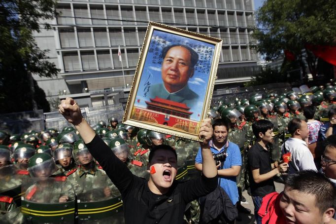 A demonstrator holding a poster of China's late Chairman Mao Zedong yells slogans during a protest against Japan's purchase of the disputed Senkaku or Diaoyu islands outside the Japanese embassy in Beijing September 15, 2012. Thousands of protesters besieged the Japanese embassy in Beijing on Saturday, hurling rocks and bottles at the building as police struggled to keep control, amid growing tensions between Asia's two biggest economies over a group of disputed islands. REUTERS/Jason Lee (CHINA - Tags: POLITICS CIVIL UNREST TPX IMAGES OF THE DAY)