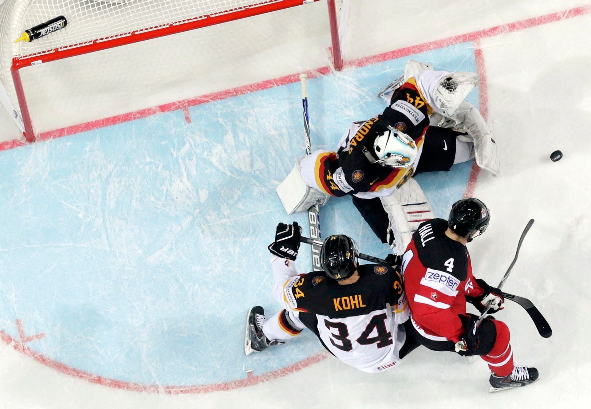 Germany's goaltender Endras and Kohl are challenged by Canada's Hall during their Ice Hockey World Championship game at the O2 arena in Prague